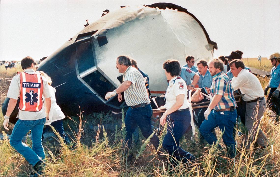 Aug. 31, 1988: Rescue workers carry the pilot of Delta 1141 to an ambulance. Most of the other survivors were able to walk away from the crash at Dallas-Fort Worth International Airport.