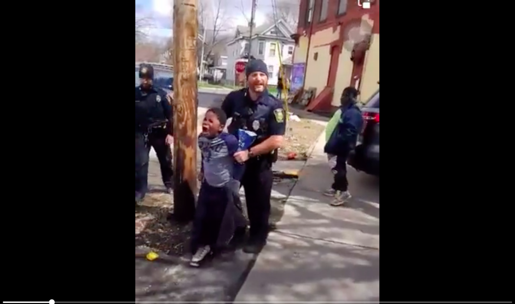 An 8-year-old boy in Syracuse was filmed by bystanders as officers grabbed him from his bike after he allegedly stole a bag of chips. No charges were pressed. (Facebook/Kenneth Jackson)