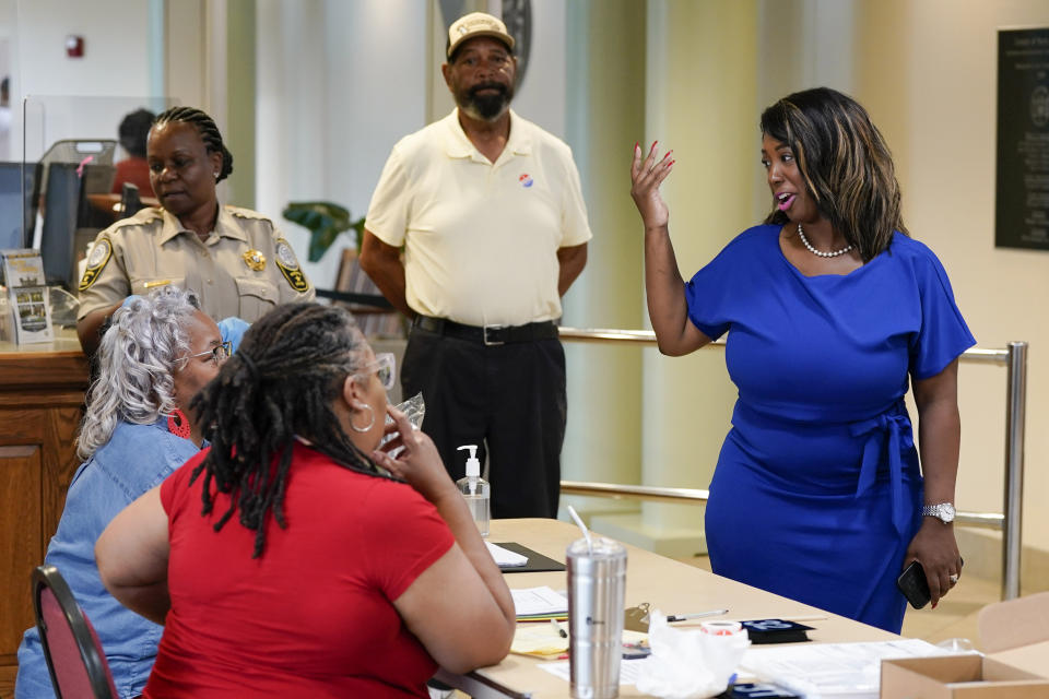 Former Virginia State Delegate Lashrecse Aird, right, talks with poll workers as she visits a polling precinct Tuesday, June 20, 2023, in Surry, Va. Aird is running against Virginia State Sen. Joe Morrissey in a Democratic primary for a newly redrawn Senate district. (AP Photo/Steve Helber)