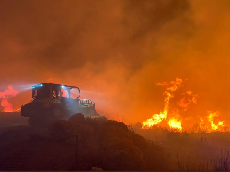 A bulldozer works at the scene of the Cave fire in Los Padres National Forest near East Camino Cielo