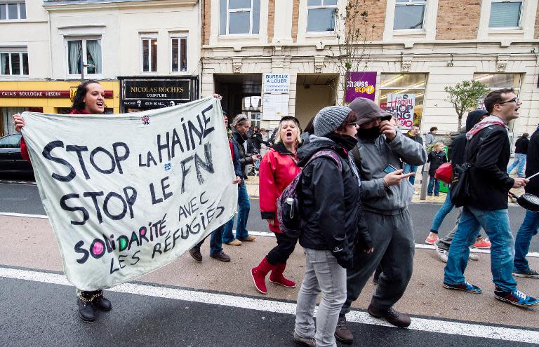 Holding a banner that reads in French, "Stop hatred, Stop the National Front" protesters hold a rally in the northern French city of Calais, on October 24, 2014