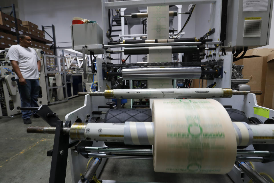 In this Friday, July 5, 2019, photo Andre Harris works on the line at beyond Green, a maker of biodegradable bags in Lake Forest, Calif. (AP Photo/Chris Carlson)