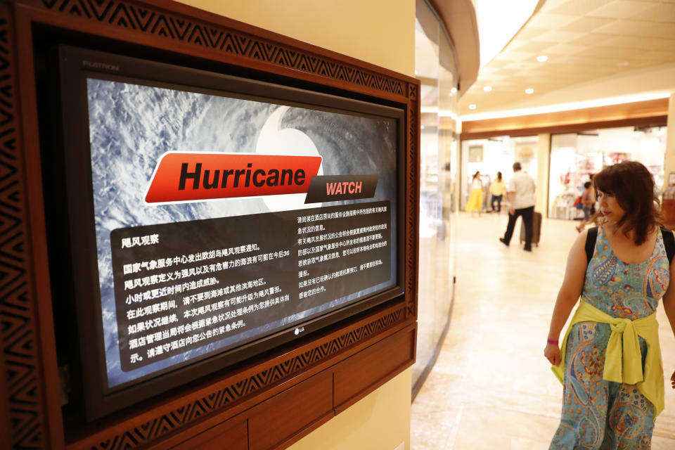 <p>A shopper walks past a monitor displaying hurricane information in several different languages inside a hotel Waikiki, Wednesday, Aug. 22, 2018, in Honolulu, Hawaii. (Photo: Marco Garcia/AP) </p>