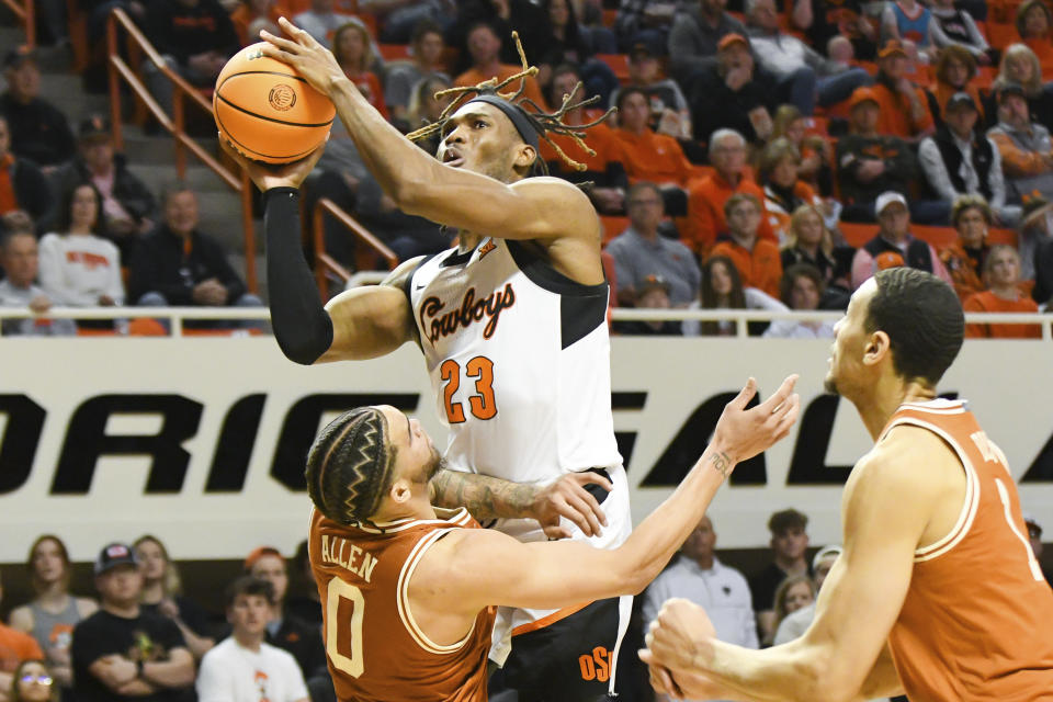 Oklahoma State forward Tyreek Smith (23) takes a shot over Texas forward Timmy Allen (0) while Texas forward Dylan Disu (1) watches during the first half of an NCAA college basketball game Saturday, Jan. 7, 2023, in Stillwater, Okla. Texas defeated Oklahoma State 56-46. (AP Photo/Brody Schmidt)