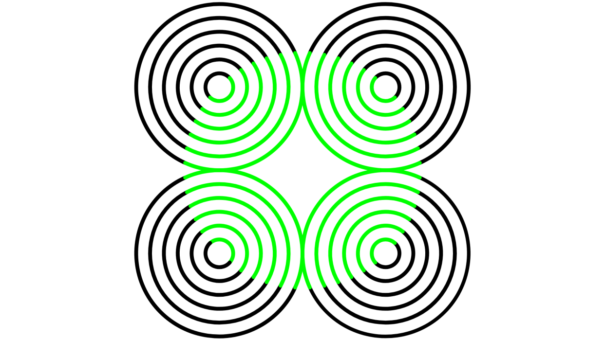  An example of the neon color spreading illusion. Here, four black circles are besides each other in a square shape. Each circle contains a series of progressively smaller circles within it. In the center there appears to be a patch of green in the shape of a circle. The background of the whole image is white. 