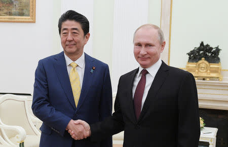 Russian President Vladimir Putin (R) shakes hands with Japanese Prime Minister Shinzo Abe during a meeting at the Kremlin in Moscow, Russia January 22, 2019. Sputnik/Alexei Druzhinin/Kremlin via REUTERS