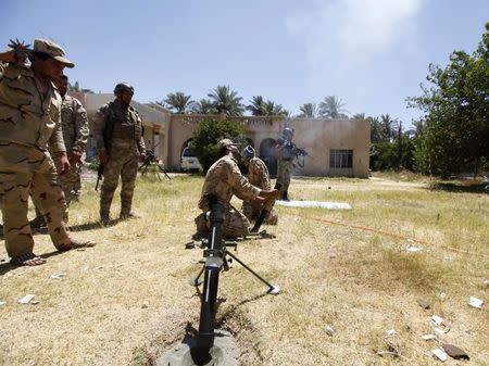 Members of the Iraqi security forces fire a mortar during clashes with fighters from Sunni militant group Islamic State of Iraq and the Levant (ISIL) in Ibrahim bin Ali village, west of Baghdad, June 24, 2014. REUTERS/Ahmed Saad