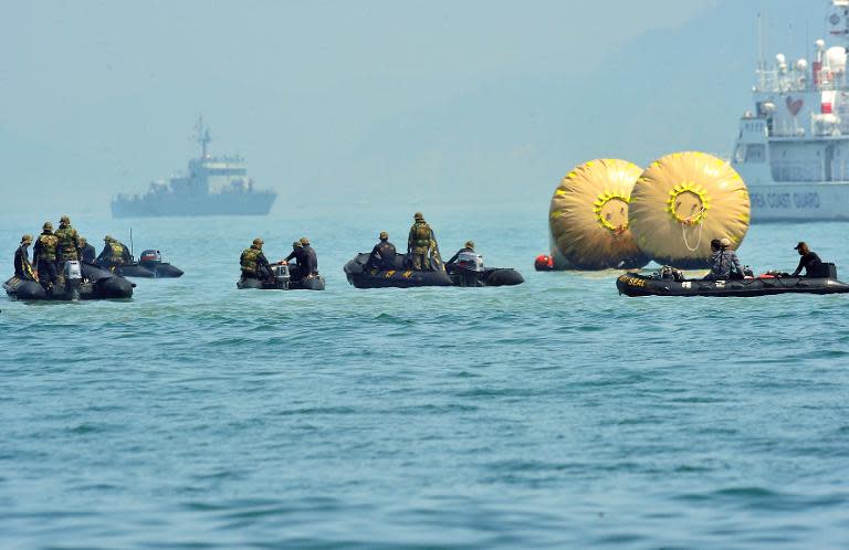 Rescue teams take part in recovery operations at the site of the sunken South Korean ferry 'Sewol', marked with buoys, at sea off Jindo on April 24, 2014