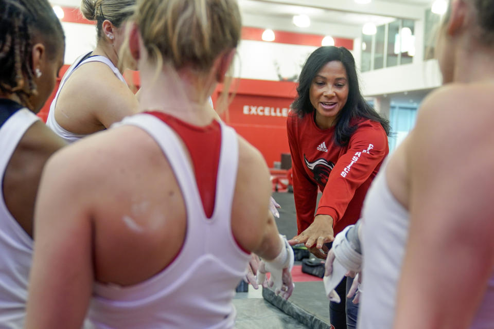 Rutgers women’s gymnastics coach Umme Salim-Beasley joins a huddle during a practice at Rutgers in Piscataway, N.J., Thursday, March 2, 2023. The Supreme Court's decision to overturn Roe v. Wade has added another complicated layer for college coaches to navigate. When the daughters of Salim-Beasley were making their list of potential college destinations, they crossed off states where abortions were sharply restricted. (AP Photo/Seth Wenig)