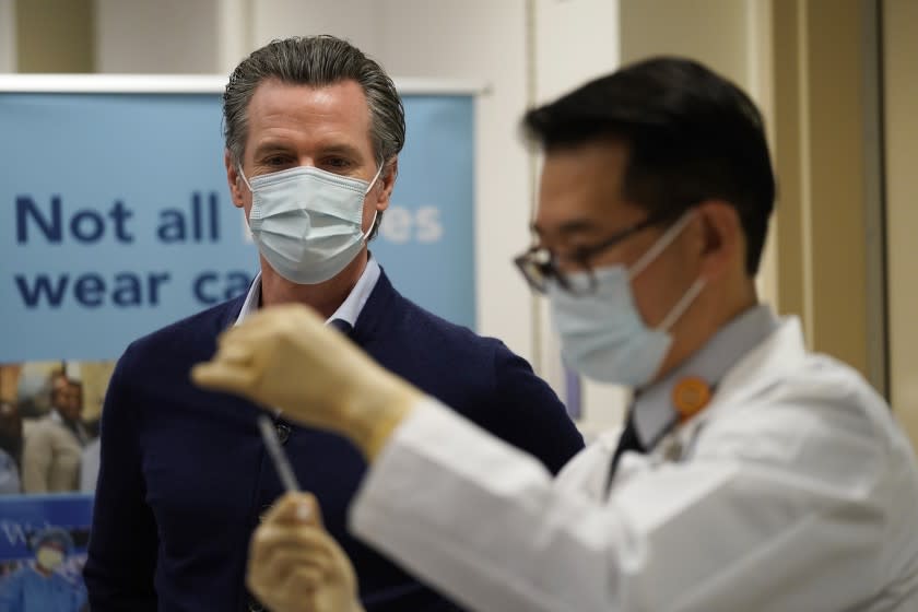 ADVANCE FOR RELEASE MARCH 14, 2021, AND THEREAFTER - File - In this Dec. 14, 2020, file photo, California Gov. Gavin Newsom watches as the Pfizer-BioNTech COVID-19 vaccine is prepared by Director of Inpatient Pharmacy David Cheng at Kaiser Permanente Los Angeles Medical Center in Los Angeles. Some of the nation's governors' offices routinely block access to public records to keep the public in the dark about key decisions involving the coronavirus pandemic. In California, Newsom's office last year denied an AP request for communications showing how the Democratic governor made decisions related to the virus outbreak. (AP Photo/Jae C. Hong, File)