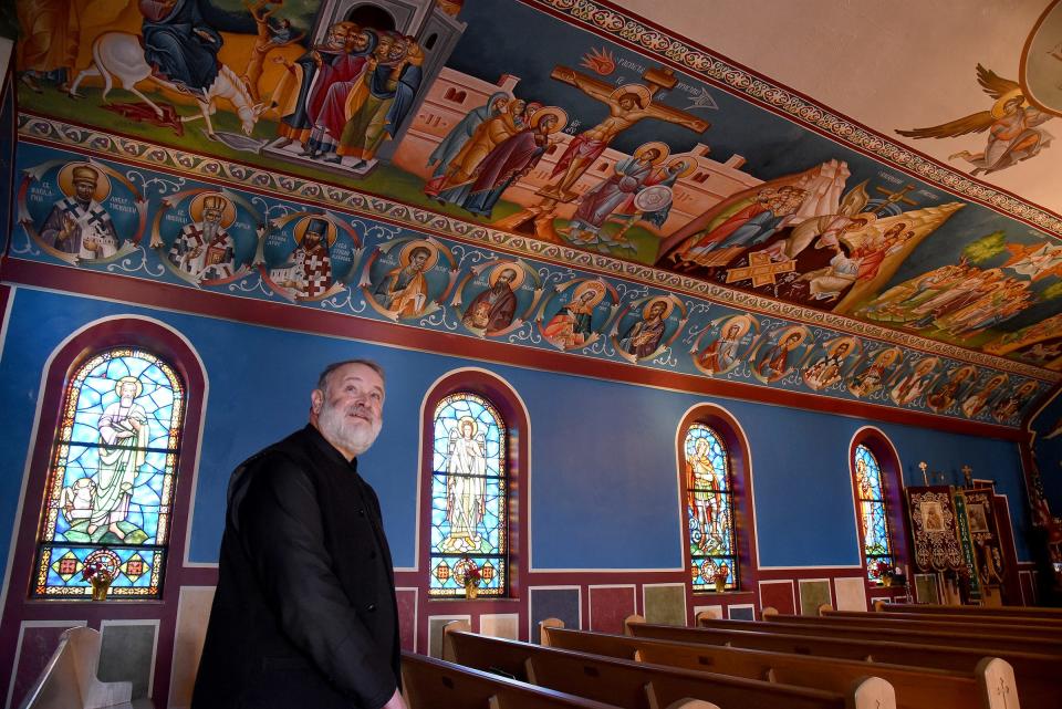 Father Radomir Obsenica, parish priest at St. George Serbian Orthodox Church in Monroe, stands among the frescos that Fillip Subotic, an artist from Serbia, created for the church. The newest phase shows the important events in Jesus' life, including his birth and death.