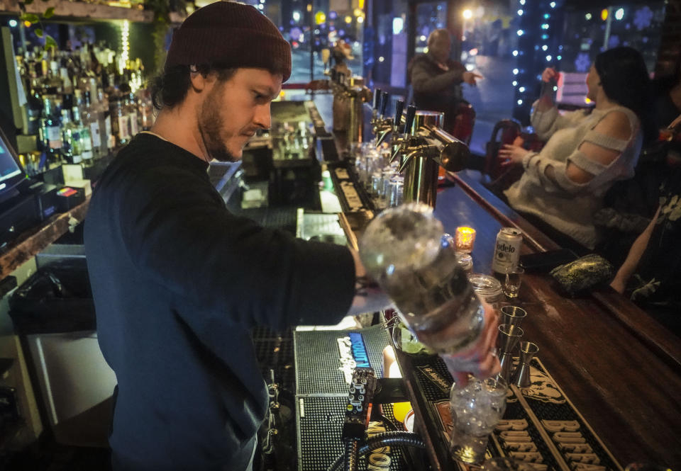 Rob Waltar, managing partner of the Fulton Grand bar, make drinks for customers, Feb. 28, 2024, in New York. Towns in New York that have never repealed Prohibition-era rules banning the sale of alcohol would be forced to lift their liquor restrictions under a bill moving through the state legislature. The bill’s sponsor argues it will spur business growth in seven towns that still have booze bans. (AP Photo/Bebeto Matthews)