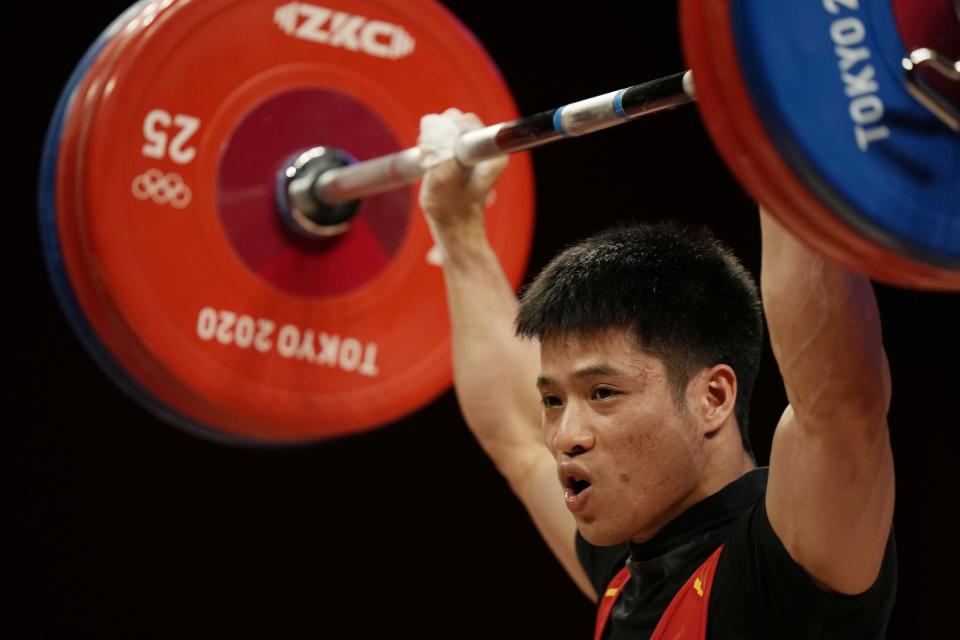 Li Fabin of China competes in the men's 61kg weightlifting event, at the 2020 Summer Olympics, Sunday, July 25, 2021, in Tokyo, Japan. (AP Photo/Luca Bruno)