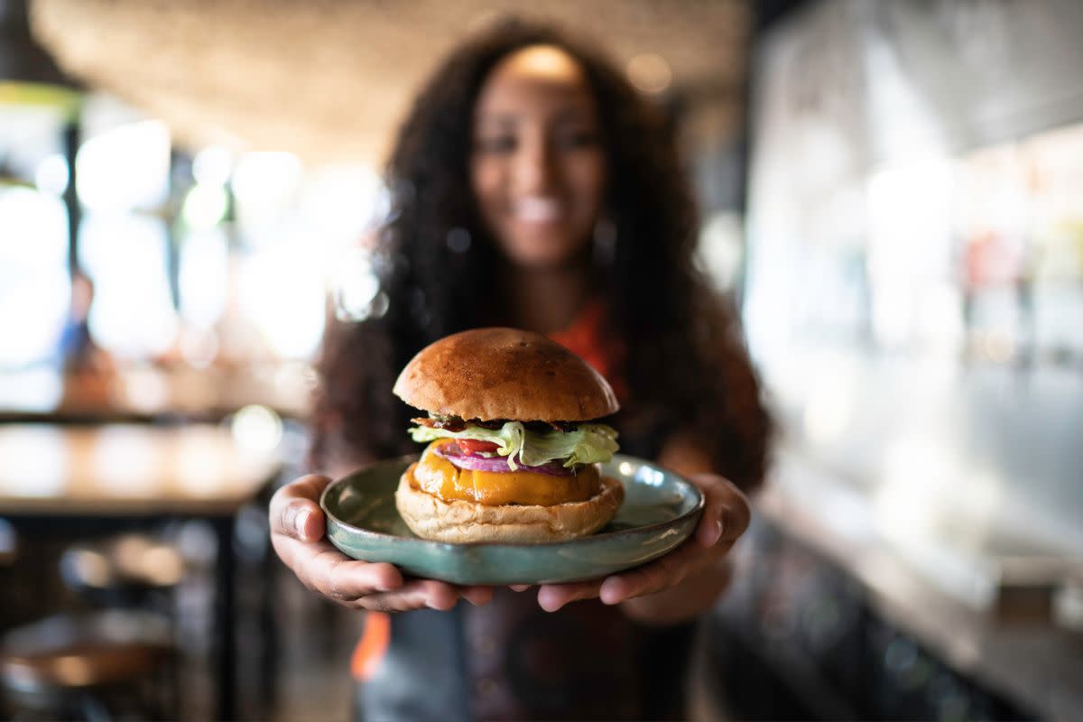 female waitress holding a sandwich in a restaurant