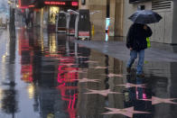 A pedestrians makes his way along a rain soaked Hollywood Blvd. in Los Angeles on Thursday, Jan. 17, 2019. The latest in a series of Pacific Ocean storms pounded California with rain and snow Thursday, prompting officials to put communities on alert for mudslides and flooding and making travel treacherous. (AP Photo/Richard Vogel)