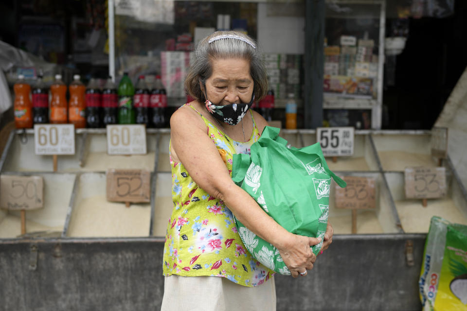 A woman carries a bag of rice from a store in Quezon city, Philippines, on Monday, Aug. 14, 2023. Countries worldwide are scrambling to secure rice after a partial ban on exports by India cut supplies by roughly a fifth. (AP Photo/Aaron Favila)
