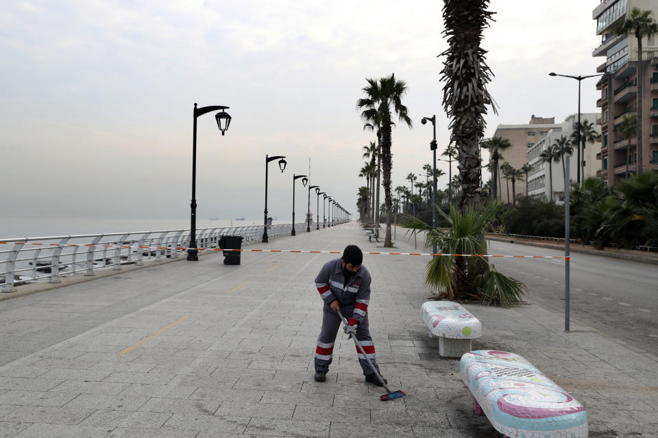 A street sweeper cleans the empty waterfront promenade as the country begins a three-week lockdown to limit the spread of coronavirus amid a post-holiday surge in the past 10 days in Beirut, Lebanon, Thursday, Jan. 7, 2021, Lebanon. (AP Photo/Bilal Hussein)