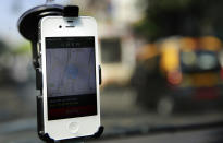 In this April 3, 2014 photo, a smartphone is mounted on the glass of an Uber car in Mumbai, India. Riding on its startup success and flush with fresh capital, taxi-hailing smartphone app Uber is making a big push into Asia. The company has in the last year started operating in 18 cities in Asia and the South Pacific including Seoul, Shanghai, Bangkok, Hong Kong and five Indian cities. (AP Photo/Rafiq Maqbool)