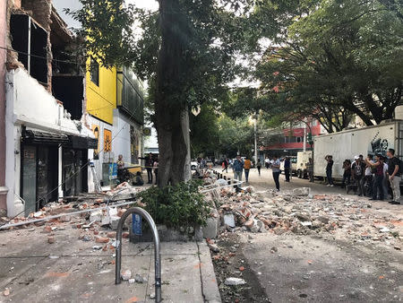 People look at the damage after an earthquake in Mexico City, Mexico, in this September 19, 2017 image from social media. trovatten.com/Social Media/via REUTERS