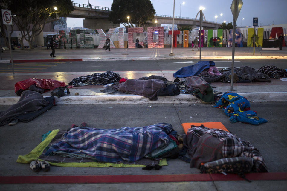 Migrants sleep on a street near the Chaparral border crossing in Tijuana, Mexico, Friday, Nov. 23, 2018. The mayor of Tijuana has declared a humanitarian crisis in his border city and says that he has asked the United Nations for aid to deal with the approximately 5,000 Central American migrants who have arrived in the city. (AP Photo/Rodrigo Abd)