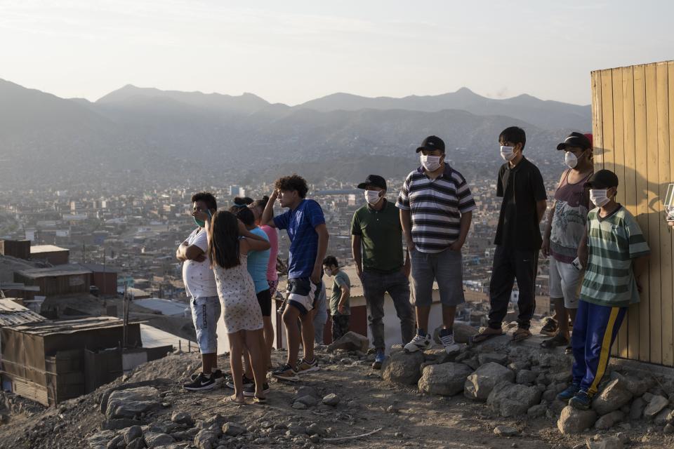 Relatives look at the Castro Castro prison from a hilltop during a prison riot in Lima, Peru, Monday, April 27, 2020. Peru's prison agency reported that three prisoners died from causes still under investigation after a riot at the Miguel Castro Castro prison in Lima. Inmates complain authorities are not doing enough to prevent the spread of coronavirus inside the prison. (AP Photo/Rodrigo Abd)