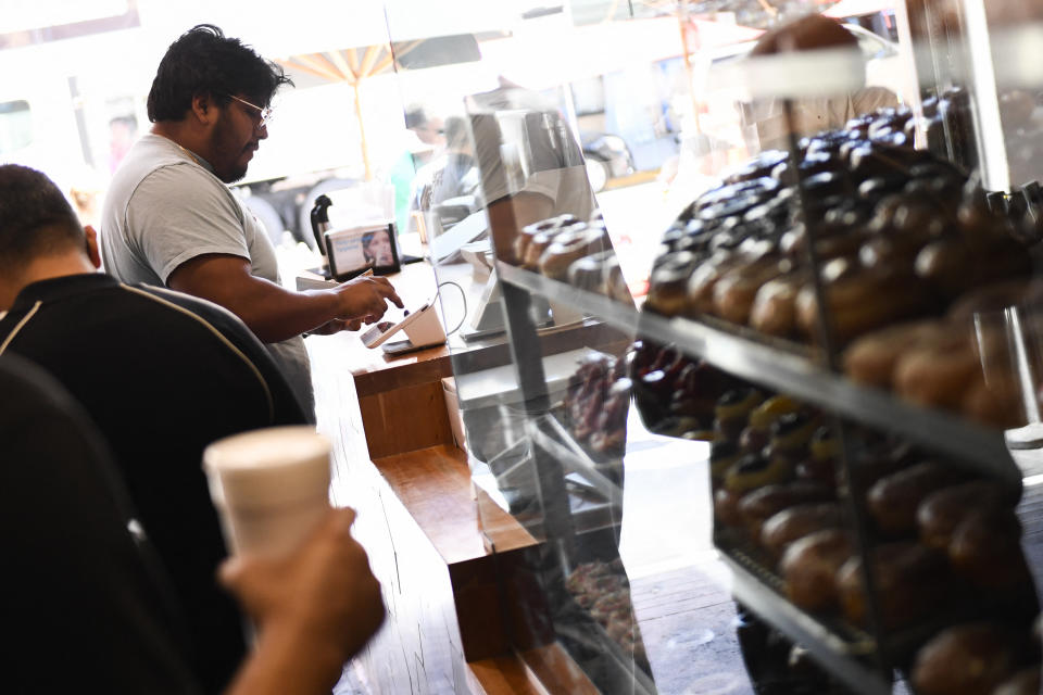 A customer uses a credit card terminal to make a purchase at The Donut Man inside Grand Central Market on March 11, 2022 in downtown Los Angeles, California. - US consumer prices hit a new 40-year high in February 2022 as the world's largest economy continued to be battered by a surge of inflation, which the fallout from Russia's invasion of Ukraine is expected to worsen. (Photo by Patrick T. FALLON / AFP) (Photo by PATRICK T. FALLON/AFP via Getty Images)