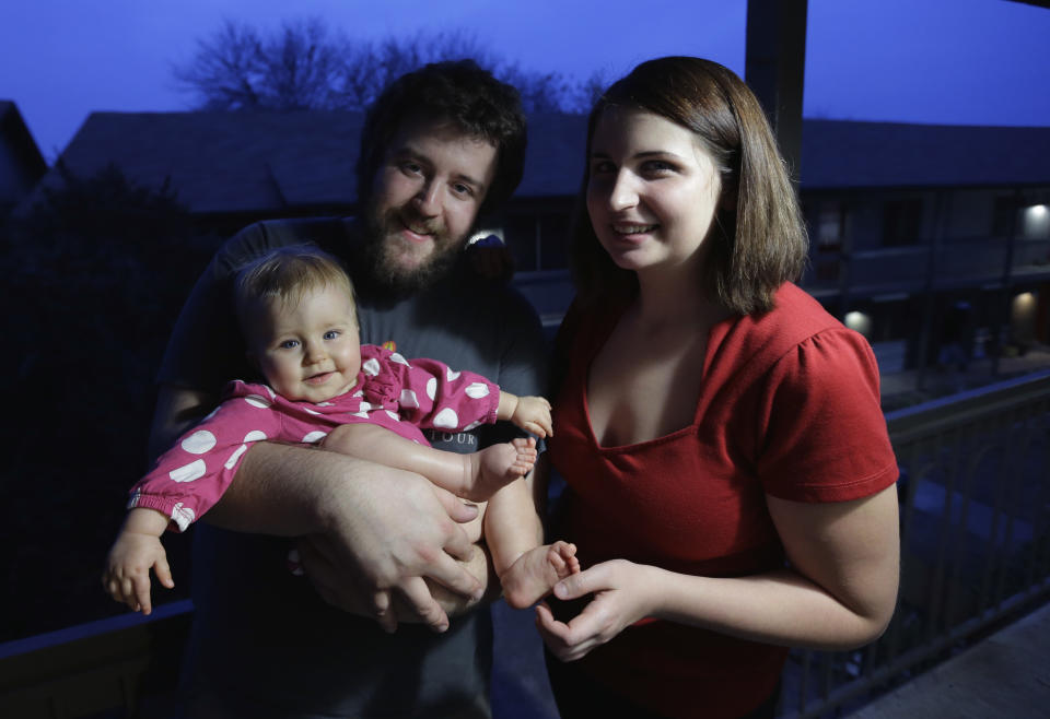 This photo taken Dec. 20, 2013 shows Amanda Leigh Pulte, right, and Matthew Gage, center, posing with their daughter Zoey at their home in Austin. No longer taboo, living together has become a more common arrangement for America's dating couples who unexpectedly become parents. It’s a major cultural shift since the days of "shotgun weddings" to avoid family embarrassment over an unplanned pregnancy. Soon-to-be-released government research and analyses of marriage data provided to The Associated Press portray an ever-changing American family. (AP Photo/Eric Gay)