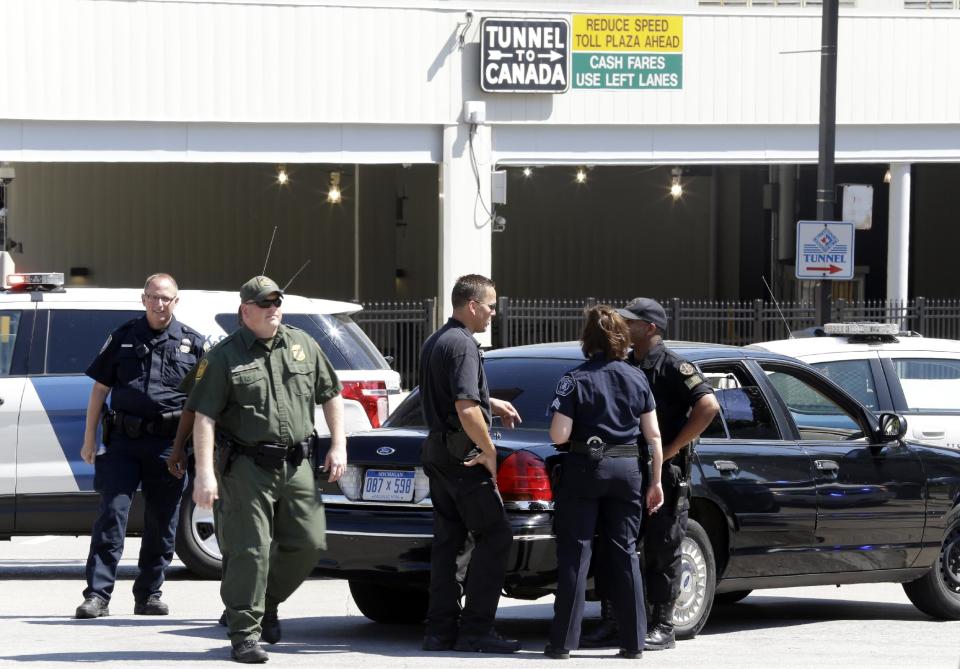 Authorities meet during a investigation of a bomb threat at the Detroit Windsor Tunnel Thursday, July 12, 2012. The tunnel was closed to traffic after the threat was called in on the Canadian side, tunnel chief executive Neal Belitsky told The Associated Press. The call was made some time after 12:30 p.m. to the duty free shop on a plaza on the tunnel's Windsor side, tunnel executive vice president Carolyn Brown said. The underwater tunnel stretches about a mile beneath the Detroit River, which is one of North America's busiest trade crossings. (AP Photo/Paul Sancya)