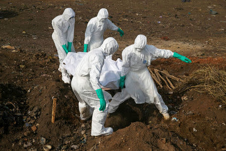 FILE PHOTO: Health workers carry the body of a suspected Ebola victim for burial at a cemetery in Freetown, Sierra Leone, December 21, 2014. REUTERS/Baz Ratner/File Photo