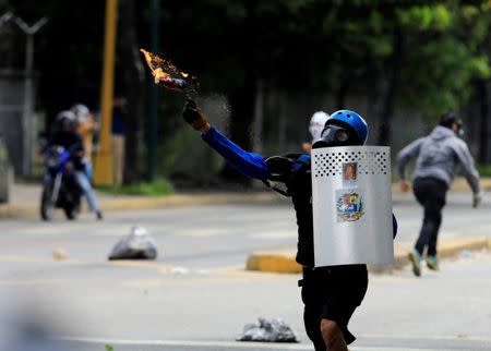 A demonstrator throws a petrol bomb while clashing with riot security forces during a rally against Venezuela's President Nicolas Maduro's government in Caracas, Venezuela, July 22, 2017. REUTERS/Marco Bello