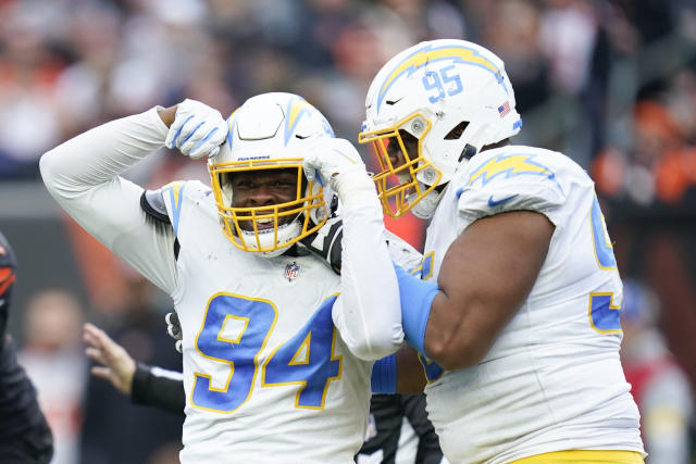 Los Angeles Chargers' Chris Rumph II (94) and Christian Covington (95) celebrate a play during the second half of an NFL football game against the Cincinnati Bengals, Sunday, Dec. 5, 2021, in Cincinnati. (AP Photo/Michael Conroy)