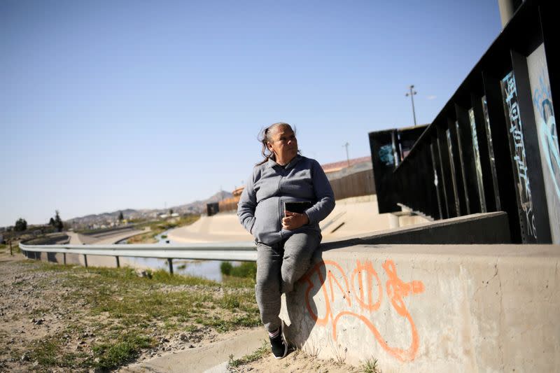 Guadalupe sits near the border fence between Mexico and U.S. where her son was shot in Ciudad Juarez