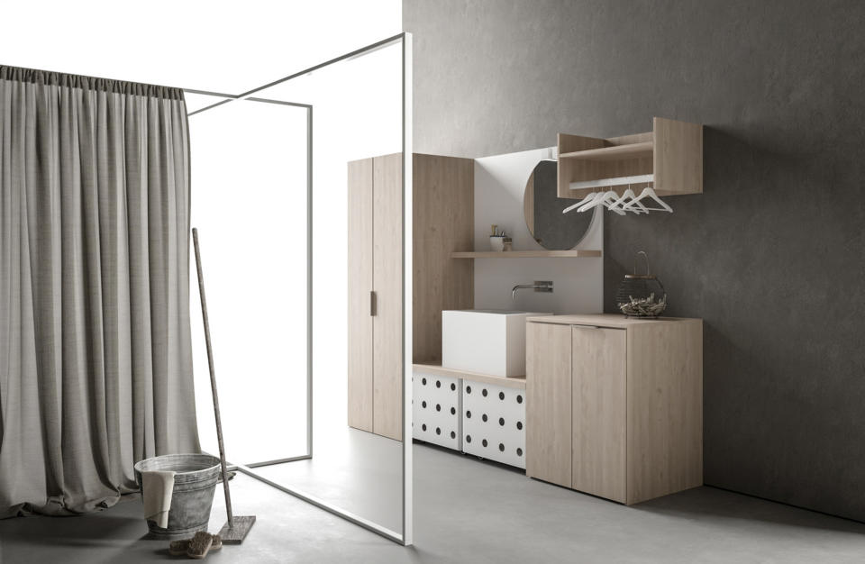 This image provided by MandiCasa shows a modern laundry room. MandiCasa’s Drop system includes base, column and hanging cabinets, racks, deep drawers, vanities and other elements. The modular collection, in neutral hues, is made of sustainably-produced wood-grained melamine. (MandiCasa/SharpThink via AP)