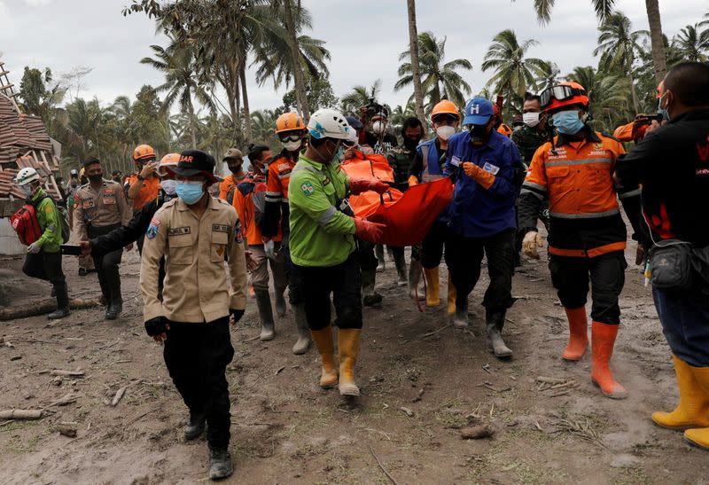 Rescue workers carry a bodybag in an area affected by the eruption of Mount Semeru volcano in Sumberwuluh, Indonesia