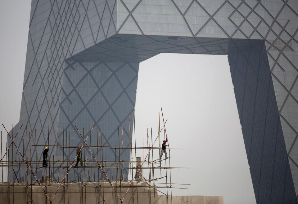 FILE - In this Wednesday, April 2, 2014 file photo, workers install scaffolding on a construction site against the China Central Television building in Beijing. China's leaders have unveiled a mini-stimulus aimed at shoring up sputtering growth in the world's No. 2 economy. Under the measures announced by Premier Li Keqiang on Wednesday, small businesses will get bigger tax breaks, social housing will be built to replace shantytowns and railway construction will be sped up. (AP Photo/Andy Wong, File)