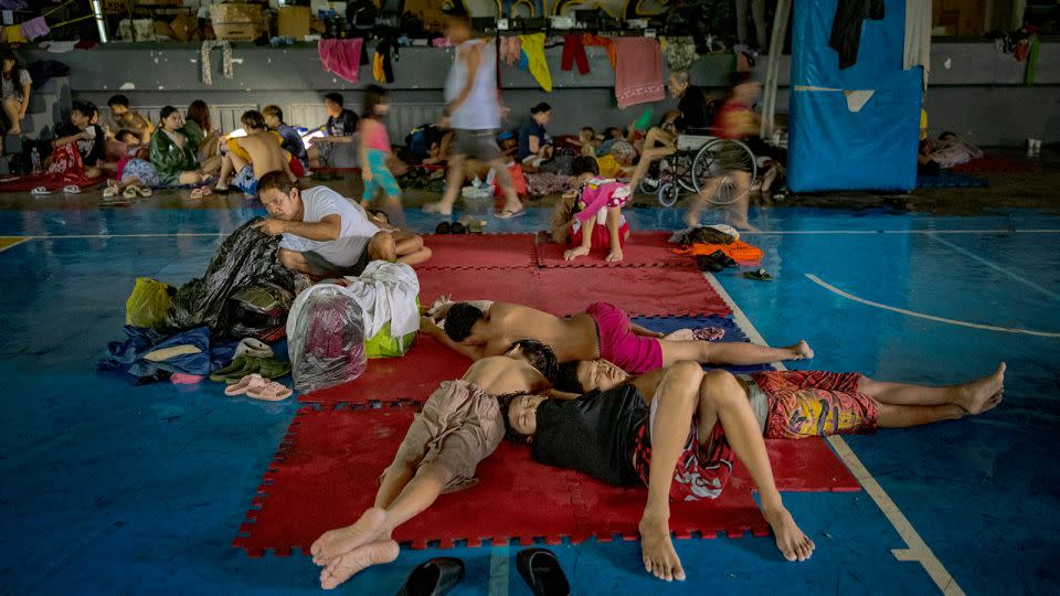 Residents whose homes were flooded by Typhoon Gaemi and monsoon rains occupy a basketball court converted into an evacuation center on July 24, 2024 in Quezon City, Philippines. - Ezra Acayan/Getty Images