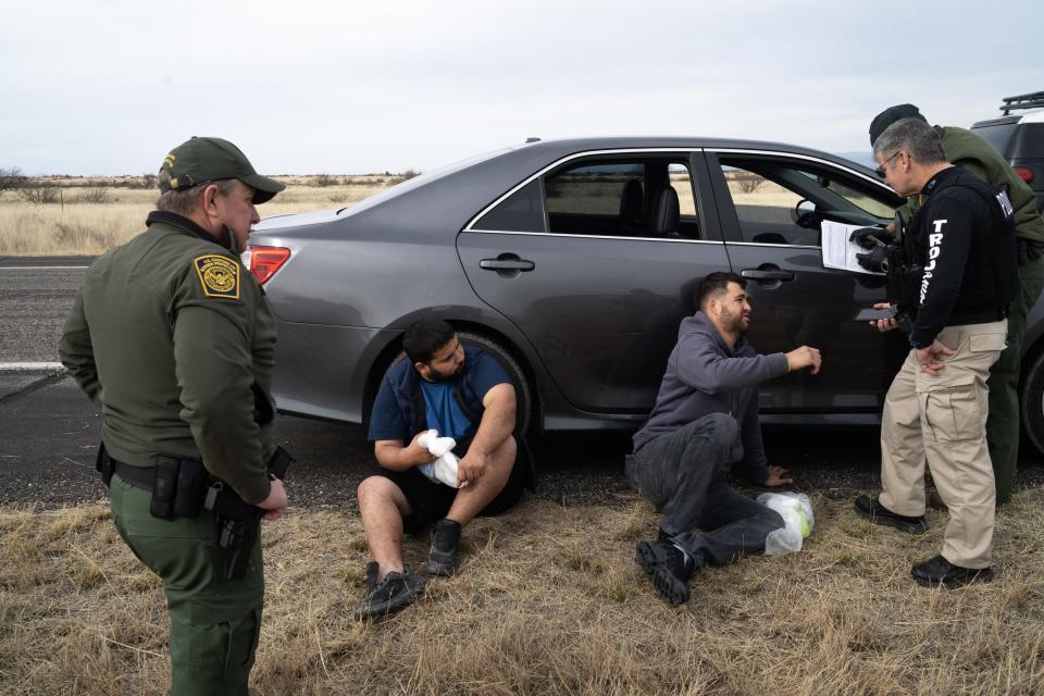 Two men, stopped on suspicion of human trafficking of three migrants, are detained by the U.S. Border Patrol on Feb. 17, 2023, in Hereford. The driver, at center in gray, drove his mother's car from California and stopped to pick up the migrants on the side of the highway in front of a Border Patrol agent, authorities said.