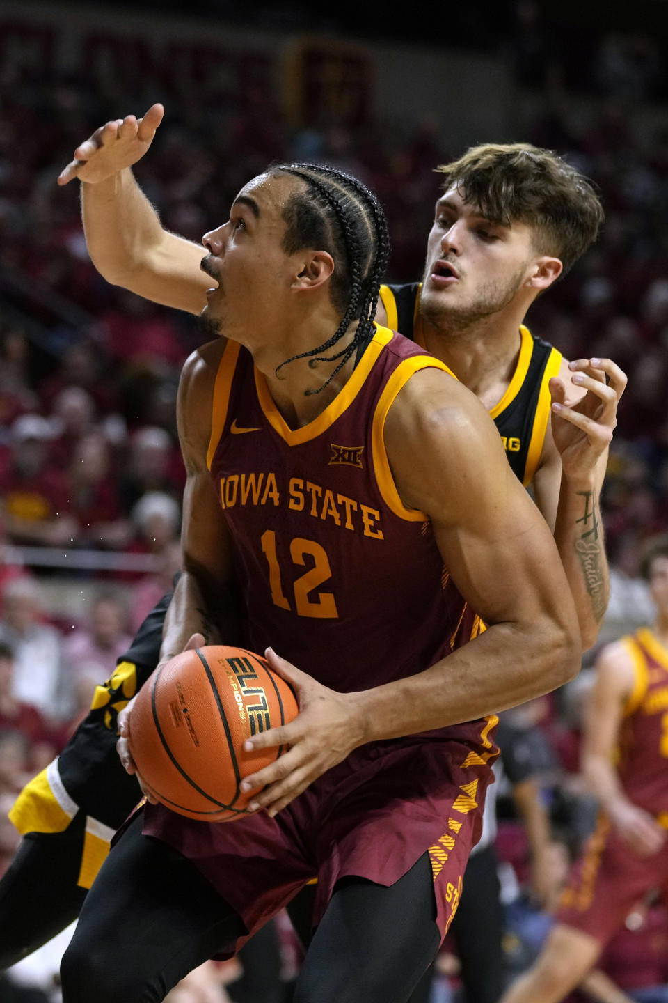 Iowa State forward Robert Jones (12) drives to the basket in front of Iowa forward Owen Freeman during the second half of an NCAA college basketball game, Thursday, Dec. 7, 2023, in Ames, Iowa. (AP Photo/Charlie Neibergall)