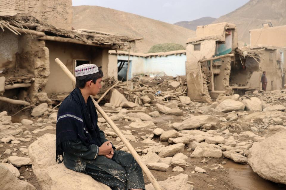 An Afghan resident sits next to his house that was damaged in flash floods in the Jalrez district of Maidan Wardak province (AFP via Getty Images)