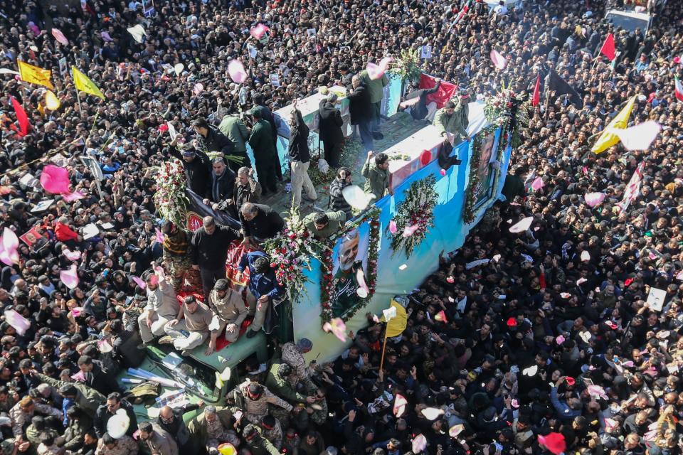 TOPSHOT - Iranian mourners gather around a vehicle carrying the coffin of slain top general Qasem Soleimani during the final stage of funeral processions, in his hometown Kerman on January 7, 2020. - Soleimani was killed outside Baghdad airport Friday in a drone strike ordered by US President Donald Trump, ratcheting up tensions with arch-enemy Iran which has vowed "severe revenge". The assassination of the 62-year-old heightened international concern about a new war in the volatile, oil-rich Middle East and rattled financial markets. (Photo by ATTA KENARE / AFP) (Photo by ATTA KENARE/AFP via Getty Images)