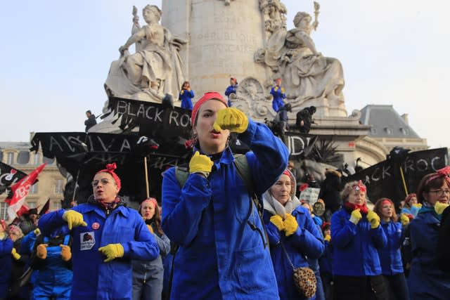 Women perform a dance against French President Emmanuel Macron during a demonstration in Paris