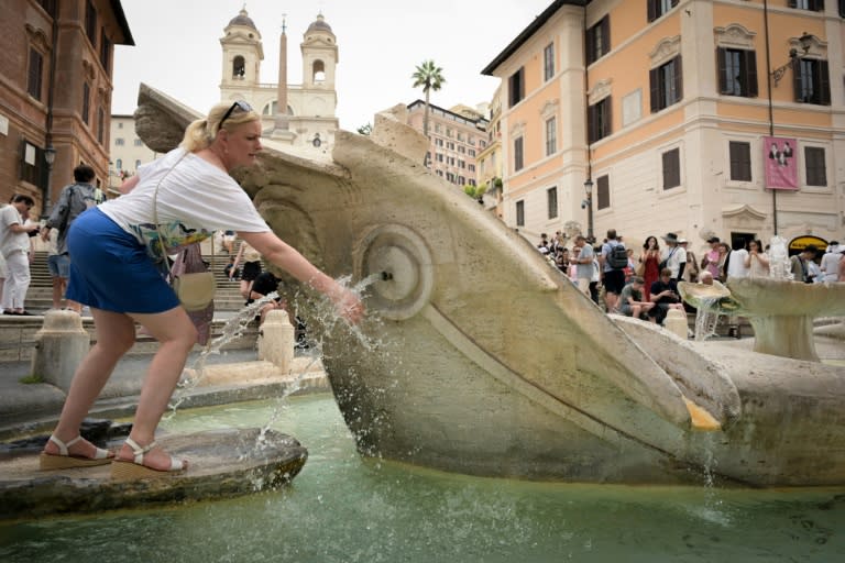 Une femme se rafraîchit près d'une fontaine de la Piazza di Spagna à Rome, le 20 juin 2024. (Tiziana FABI)