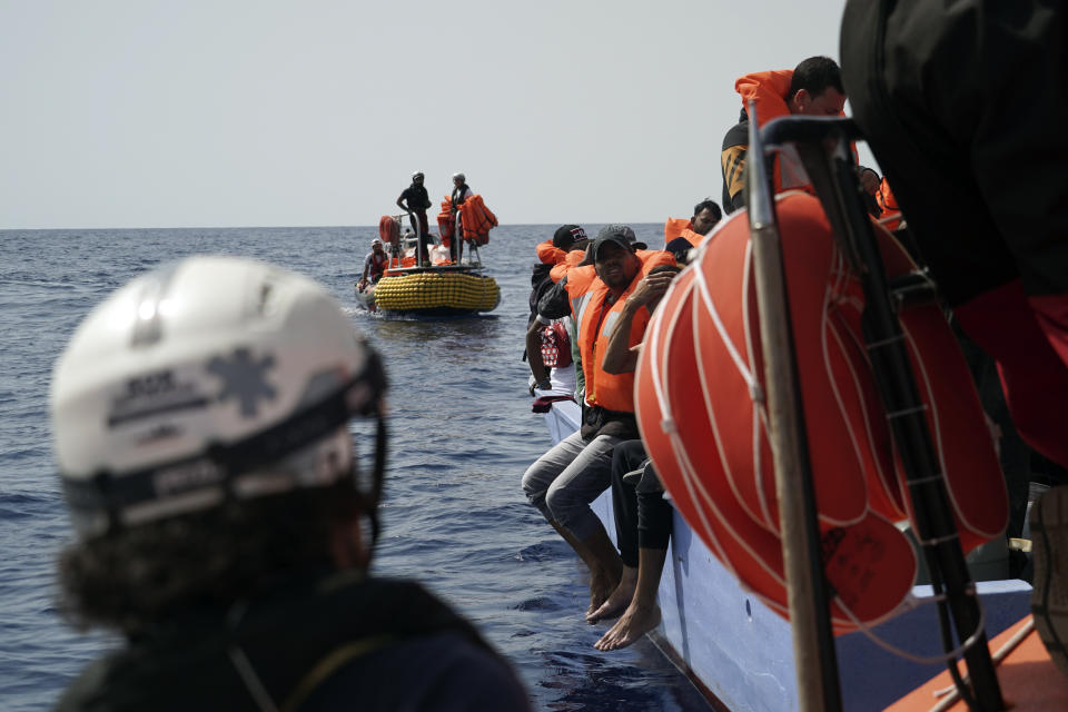 Migrants listen to SOS Mediterranee staff during a rescue operation some 53 nautical miles (98 kilometers) from the coast of Libya in the Mediterranean Sea, Tuesday, Sept. 17, 2019. The humanitarian rescue ship Ocean Viking pulled 48 people from a small and overcrowded wooden boat including a newborn and a pregnant woman. (AP Photo/Renata Brito)