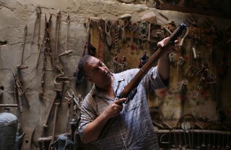 Palestinian carpenter Marwan Shahwan displays what he says is a rifle from the British era, in Khan Younis in the southern Gaza Strip June 18, 2018. Picture taken June 18, 2018. REUTERS/Ibraheem Abu Mustafa