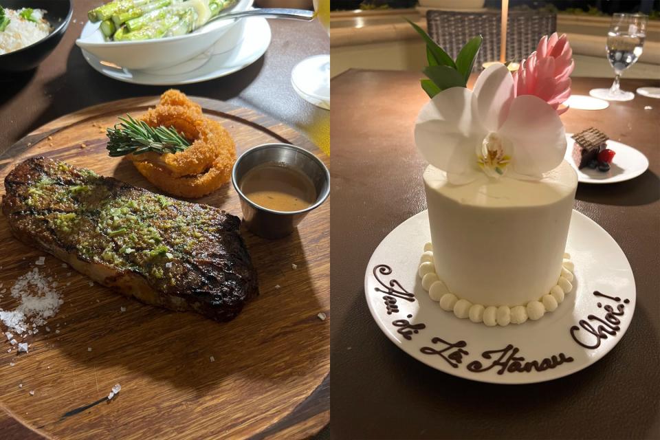 A steak on a circular wooden board served with sauce, salt, and onion rings (left); a coconut-cream birthday cake topped with flowers (right).