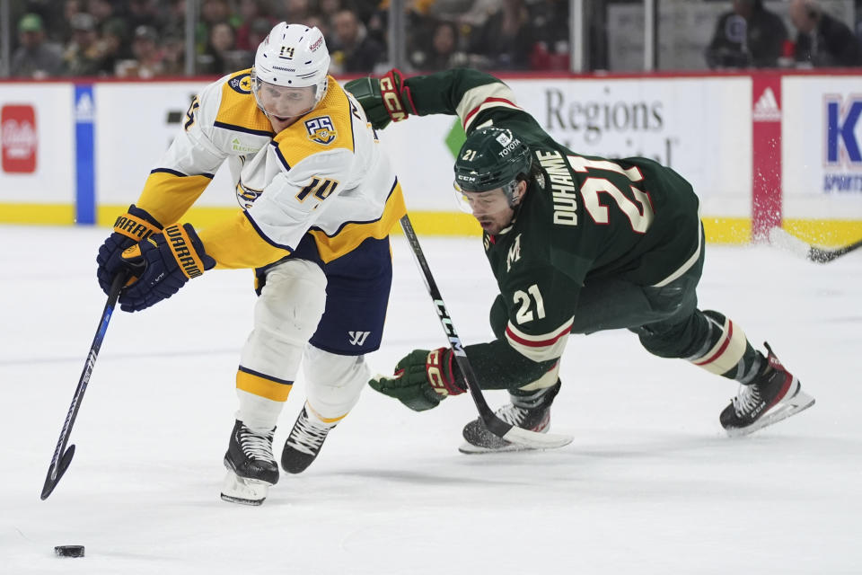 Nashville Predators center Gustav Nyquist (14) skates with the puck as Minnesota Wild right wing Brandon Duhaime (21) follows during the second period of an NHL hockey game Thursday, Jan. 25, 2024, in St. Paul, Minn. (AP Photo/Abbie Parr)