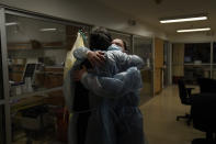 Chaplain Kevin Deegan, left, and registered nurse Michelle Stephens comfort each other in a COVID-19 unit at Providence Holy Cross Medical Center in the Mission Hills section of Los Angeles on Saturday, Jan. 9, 2021. "He is my friend. He is a trusted co-worker. He is my partner in crime. We absolutely have been through a lot together," said the nurse. (AP Photo/Jae C. Hong)