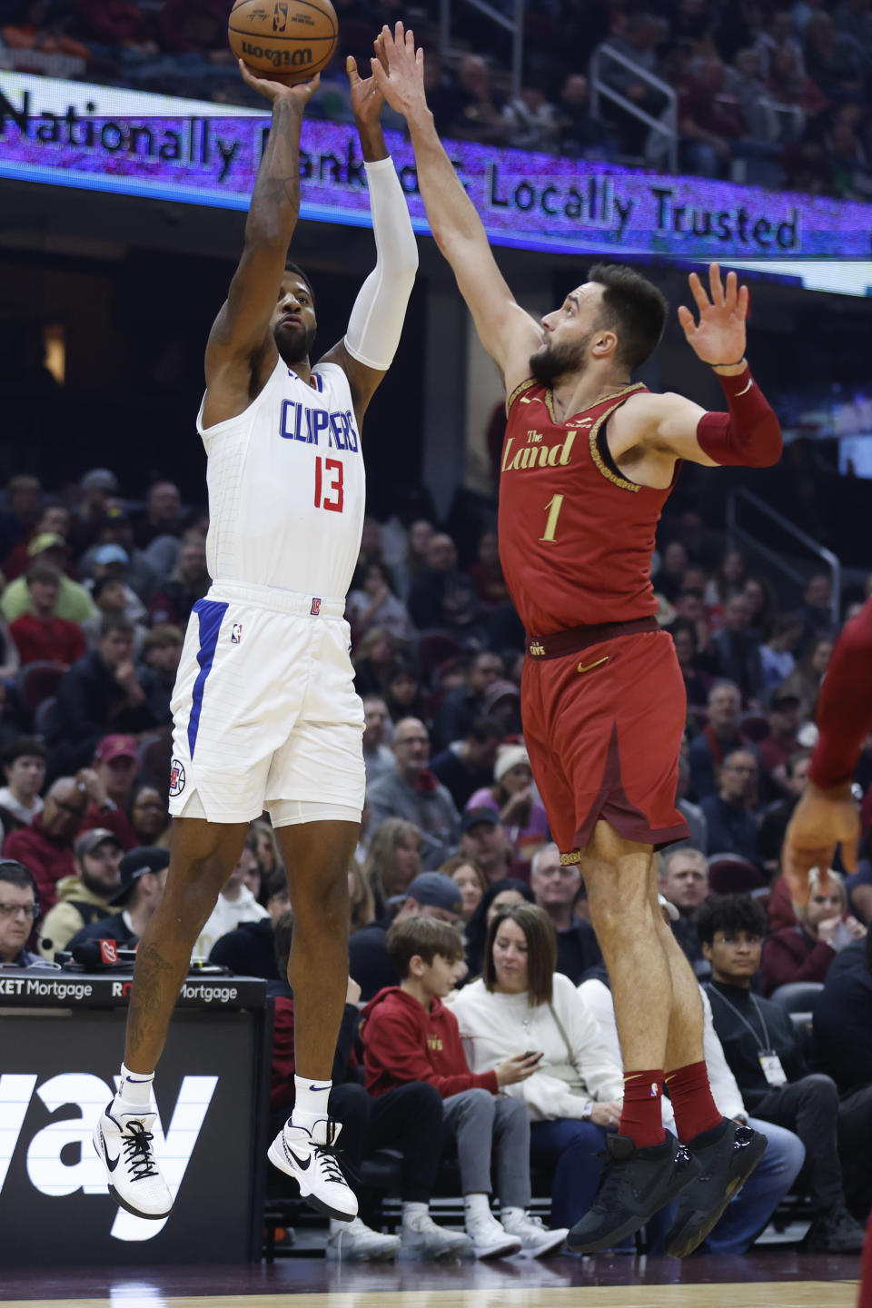 Los Angeles Clippers forward Paul George (13) shoots against Cleveland Cavaliers guard Max Strus (1) during the first half of an NBA basketball game, Monday, Jan. 29, 2024, in Cleveland. (AP Photo/Ron Schwane)