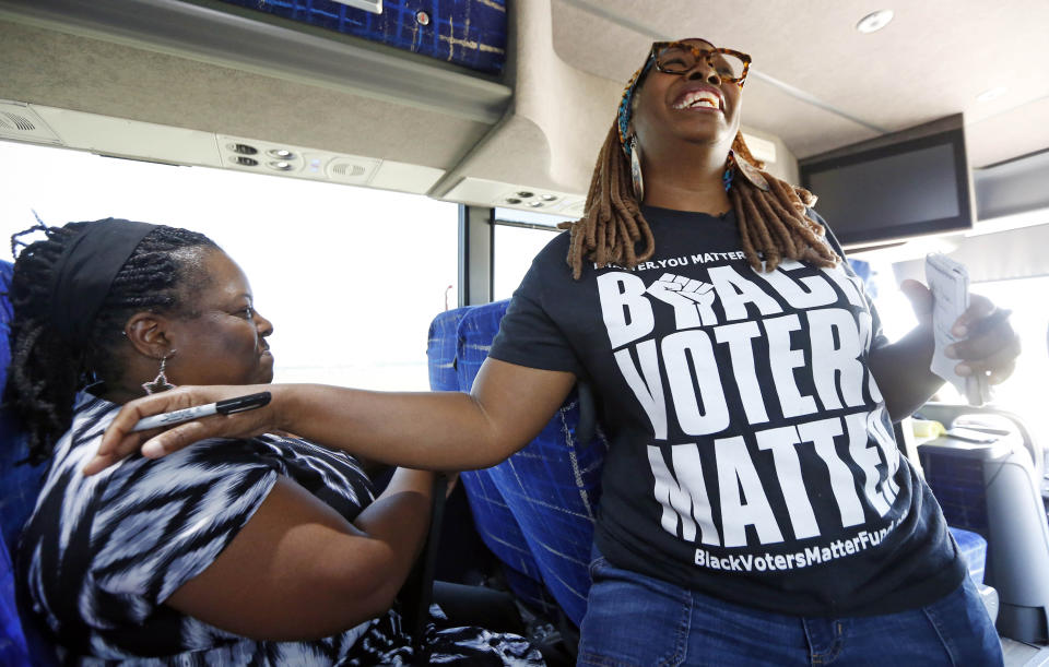 In this Aug. 24, 2018 photo, LaTosha Brown, right, co-founder of Black Voters Matter, laughs with Mable Spears-Starks, President and CEO of MACE, Mississippi Action for Community Education, aboard a bus tour in the Mississippi Delta. The tour was in part to introduce national media to a number of hands-on organizations, mainly led by women, that are working throughout the Delta and to build interest and excitement among the groups for the upcoming election, documenting the campaigning in locales with important upcoming races where black turnout might be key. (AP Photo/Rogelio V. Solis)