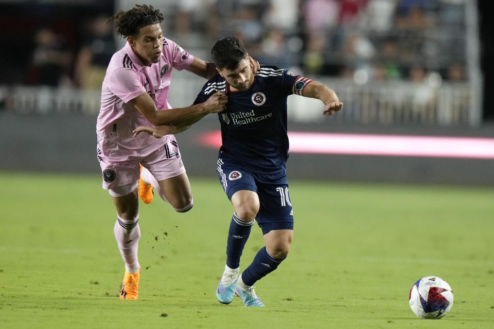 Inter Miami midfielder David Ruiz, left, grabs New England Revolution midfielder Carles Gil (10) as they chase the ball during the first half of an MLS soccer match Saturday, May 13, 2023, in Fort Lauderdale, Fla. (AP Photo/Lynne Sladky)